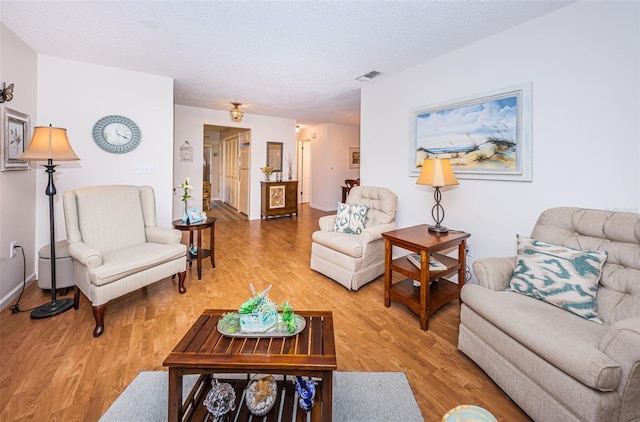 living room with hardwood / wood-style floors and a textured ceiling