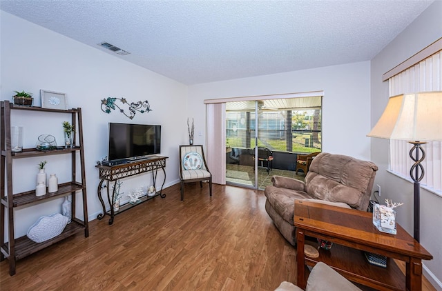 living room with wood-type flooring and a textured ceiling