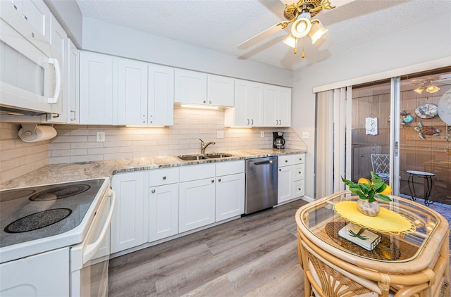 kitchen with white cabinetry, white appliances, and sink