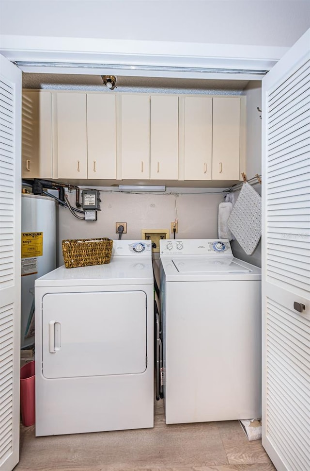 laundry area featuring cabinets, washing machine and clothes dryer, and water heater