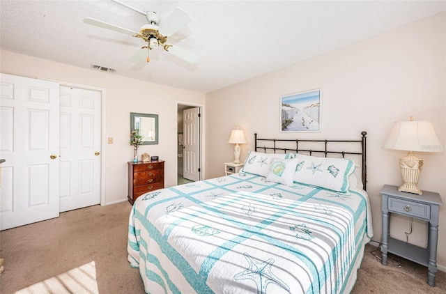 carpeted bedroom with a textured ceiling and ceiling fan