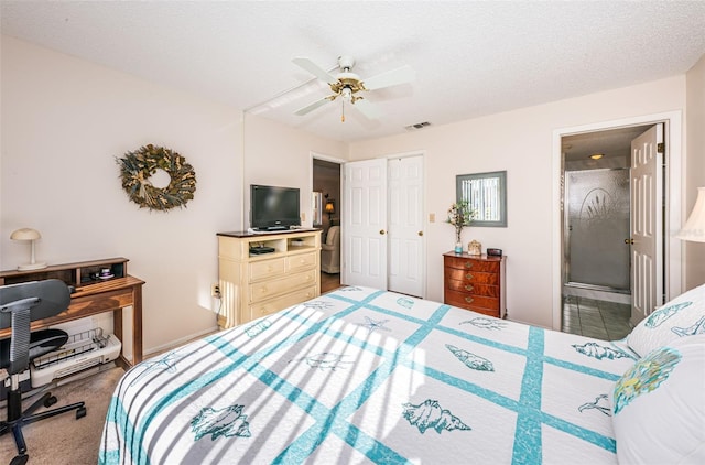 carpeted bedroom with ceiling fan, ensuite bathroom, a textured ceiling, and a closet