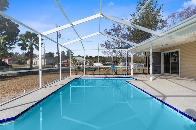 view of pool with glass enclosure and a patio area