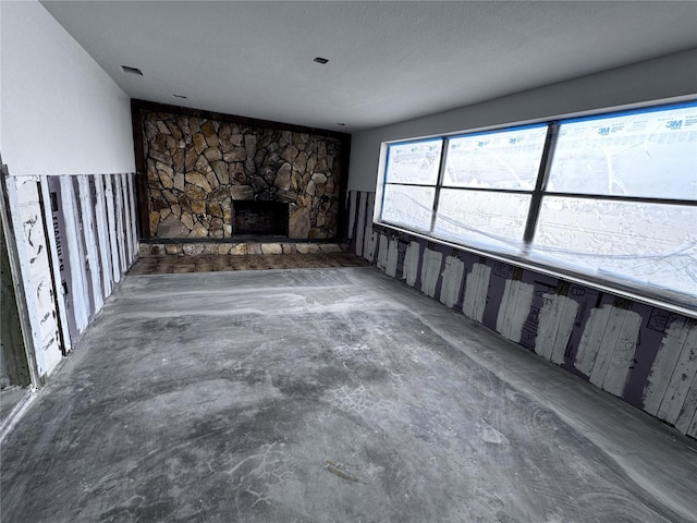 unfurnished living room with a stone fireplace