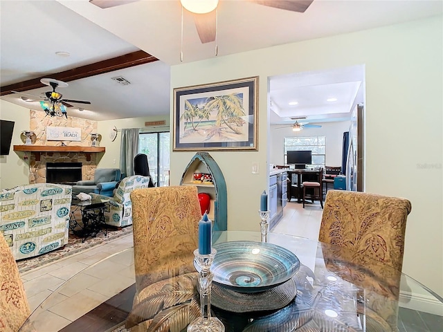 tiled dining room featuring a fireplace, beamed ceiling, and ceiling fan