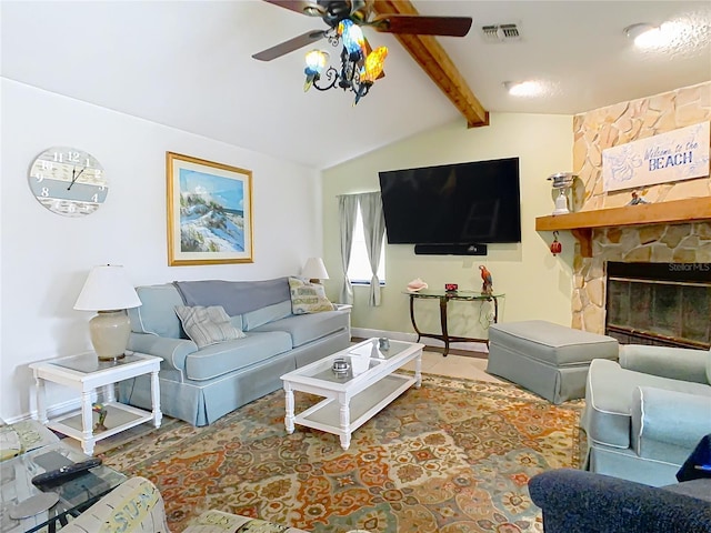 living room with ceiling fan, lofted ceiling with beams, and a stone fireplace