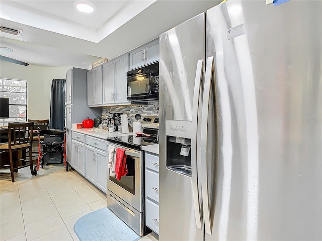 12529 Shadow Ridge Blvd, Hudson, FL 34669 - kitchen featuring appliances with stainless steel finishes, gray cabinets, light tile patterned flooring, backsplash, and light countertops
