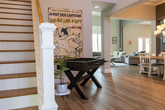 stairs featuring decorative columns, hardwood / wood-style flooring, and crown molding