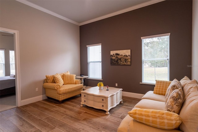 living room with wood-type flooring, crown molding, and a healthy amount of sunlight