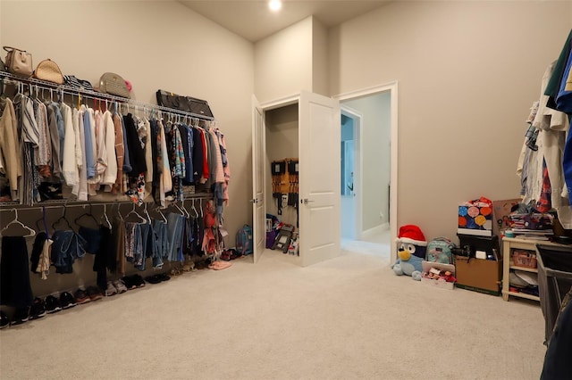 spacious closet with a high ceiling and carpet floors