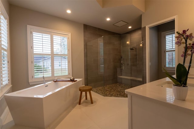 bathroom with plus walk in shower, tile patterned flooring, and vanity