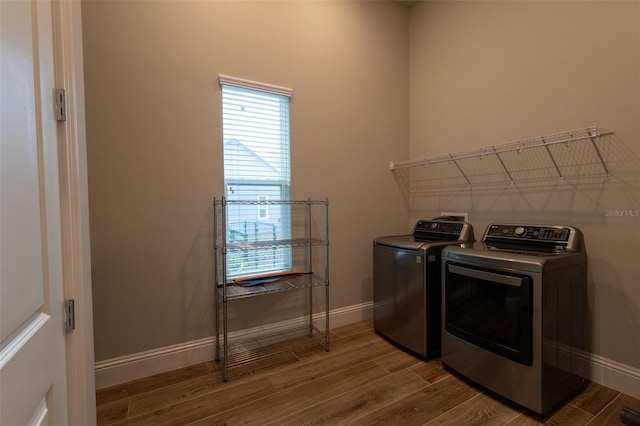 clothes washing area with hardwood / wood-style flooring and washing machine and dryer