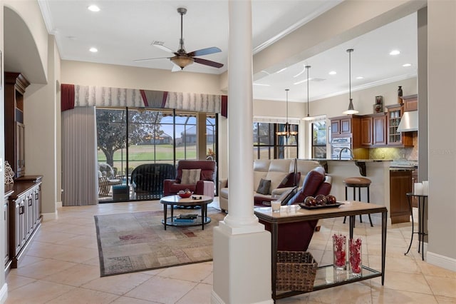 tiled living room with crown molding, decorative columns, and ceiling fan