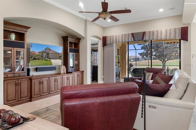 tiled living room with crown molding and ceiling fan