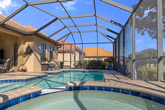 view of swimming pool featuring a lanai, a patio area, and an in ground hot tub