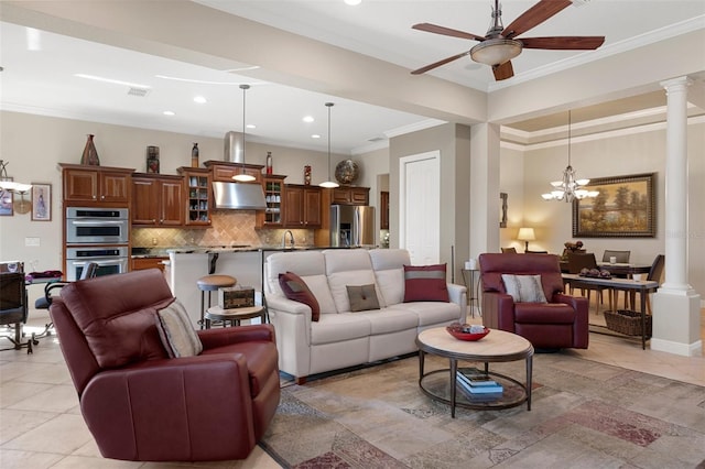 living room with sink, crown molding, light tile patterned flooring, ceiling fan with notable chandelier, and ornate columns