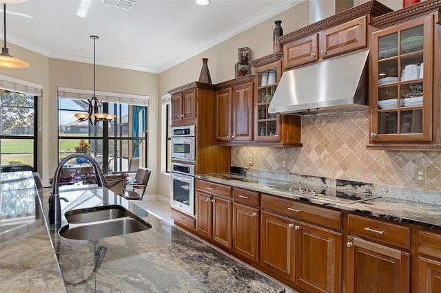 kitchen with black electric stovetop, pendant lighting, sink, and exhaust hood