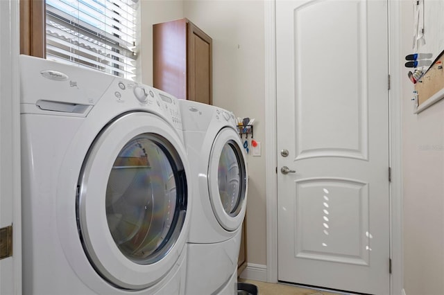 laundry area with cabinets, light tile patterned flooring, and washing machine and clothes dryer