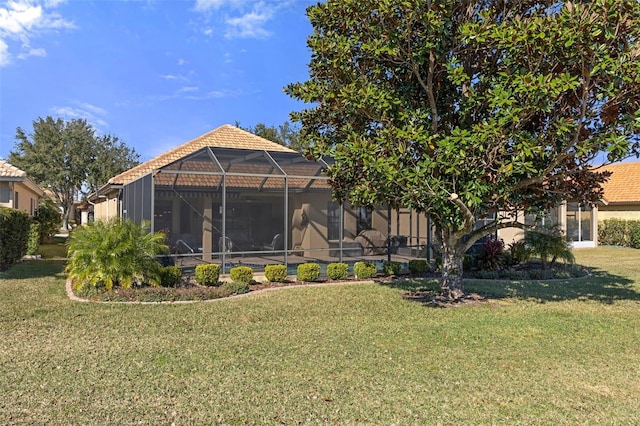 back of property featuring a yard and glass enclosure