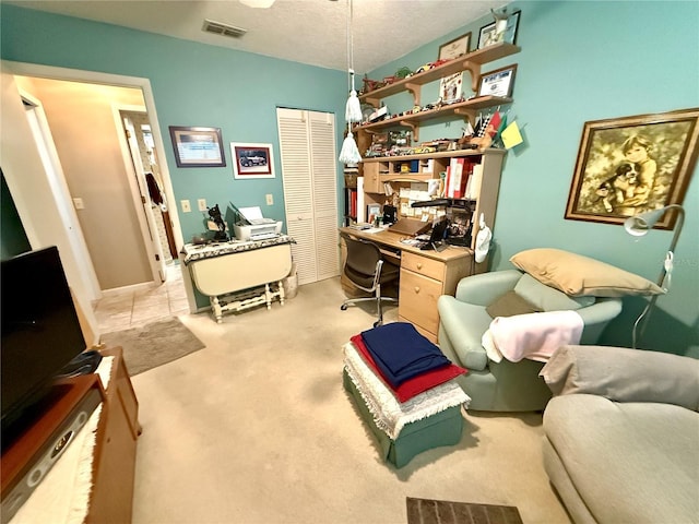 carpeted home office featuring a textured ceiling