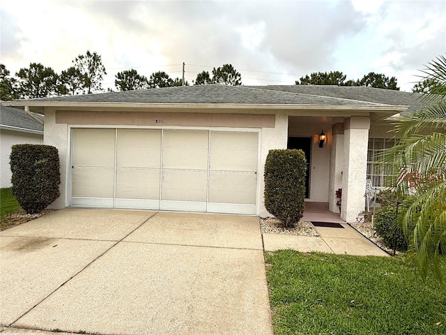 8111 Merrimac Dr, Port Richey, FL 34668 - view of front of house with an attached garage, concrete driveway, stucco siding, and roof with shingles
