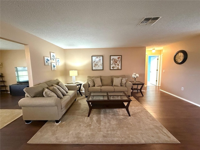 living room with wood-type flooring and a textured ceiling