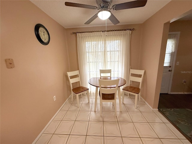 dining space with ceiling fan and light tile patterned flooring