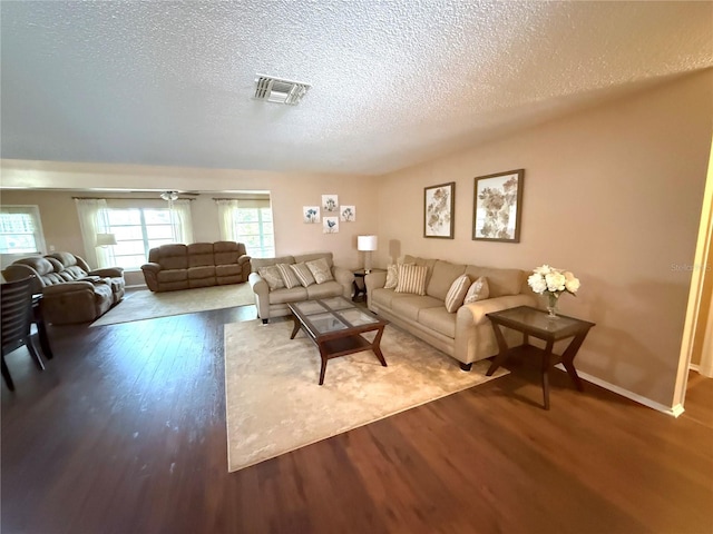 living room featuring wood-type flooring and a textured ceiling