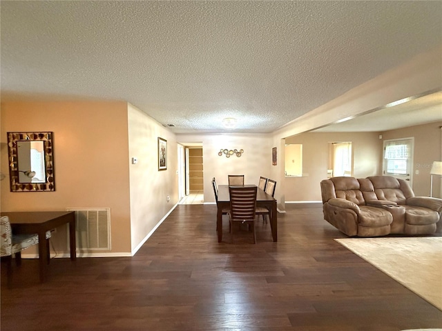 dining room featuring dark hardwood / wood-style floors and a textured ceiling