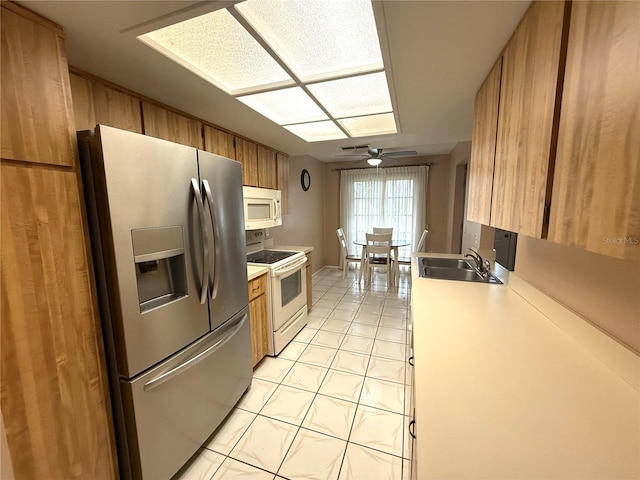 kitchen with ceiling fan, white appliances, light tile patterned flooring, and sink