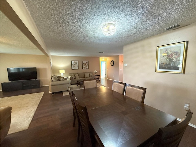 dining area featuring dark hardwood / wood-style floors and a textured ceiling