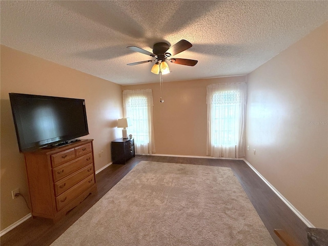 unfurnished bedroom featuring a textured ceiling, dark hardwood / wood-style floors, and ceiling fan