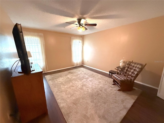 unfurnished room with dark wood-type flooring, ceiling fan, and a textured ceiling