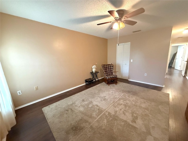 unfurnished room with ceiling fan, dark hardwood / wood-style floors, and a textured ceiling