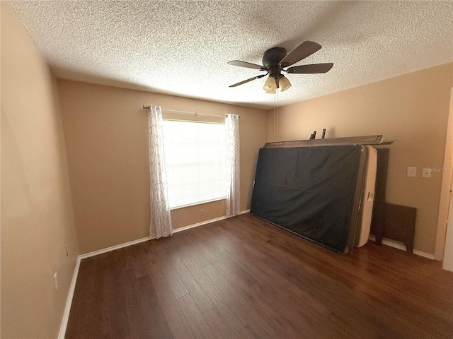 interior space with dark wood-type flooring, ceiling fan, and a textured ceiling