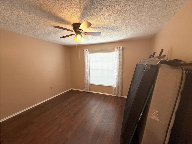 interior space with a textured ceiling, dark wood-type flooring, and ceiling fan