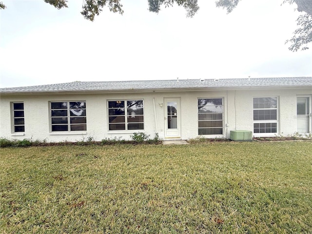 ranch-style home with a front yard and central air condition unit