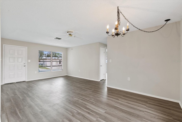 empty room with hardwood / wood-style flooring, a textured ceiling, and ceiling fan with notable chandelier