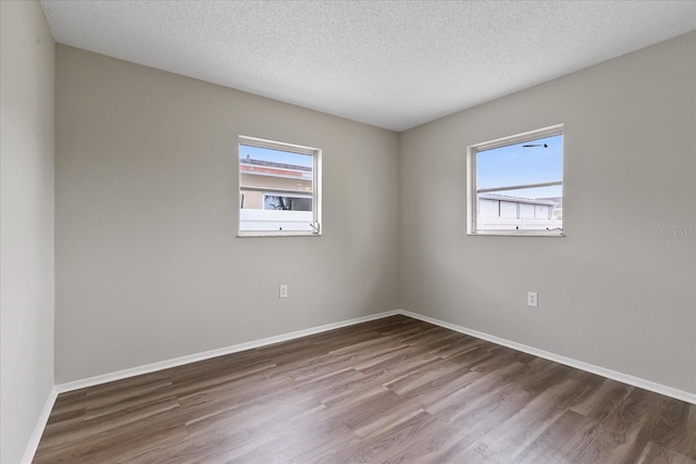 empty room featuring a textured ceiling and hardwood / wood-style flooring