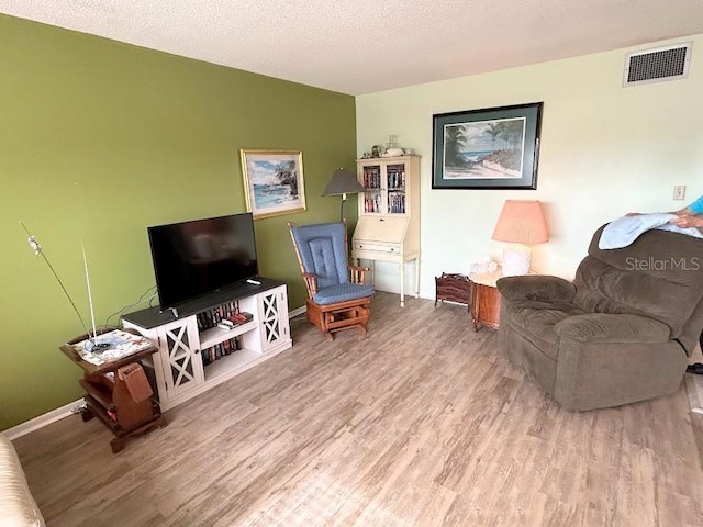 living room featuring a textured ceiling and hardwood / wood-style floors