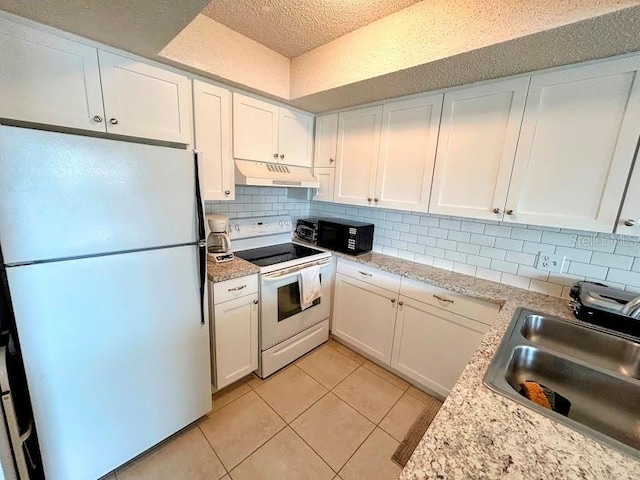 kitchen featuring white cabinetry, tasteful backsplash, white range with electric cooktop, sink, and fridge