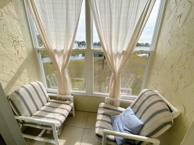 sunroom featuring a wealth of natural light and a water view