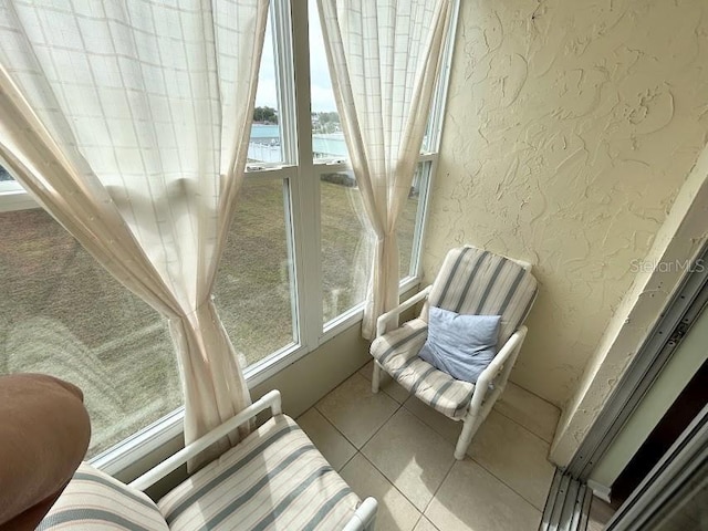 sunroom featuring a water view