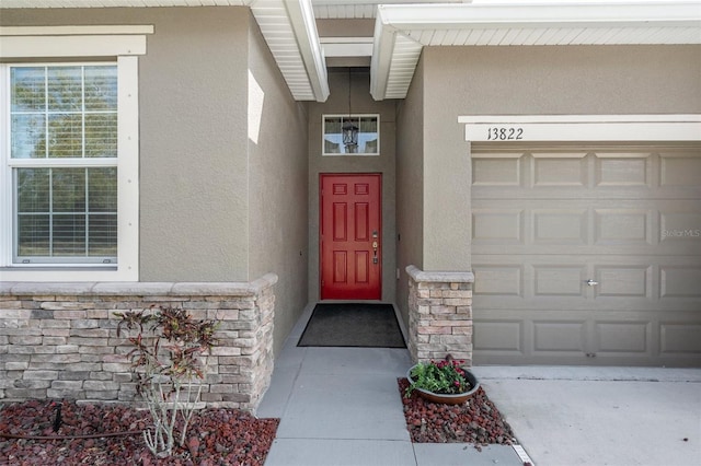 view of exterior entry with stone siding and stucco siding