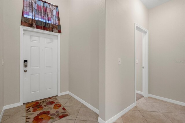 entrance foyer with light tile patterned floors and baseboards