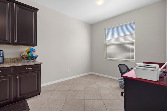 office space with baseboards and light tile patterned flooring