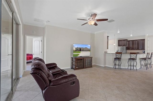 living area with ornamental molding, visible vents, and baseboards