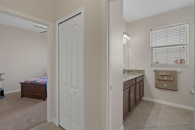 bathroom with tile patterned flooring, vanity, and baseboards