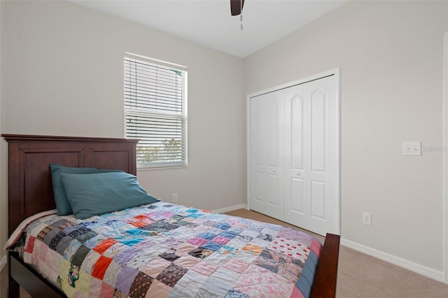 bedroom featuring a ceiling fan, baseboards, a closet, and light colored carpet