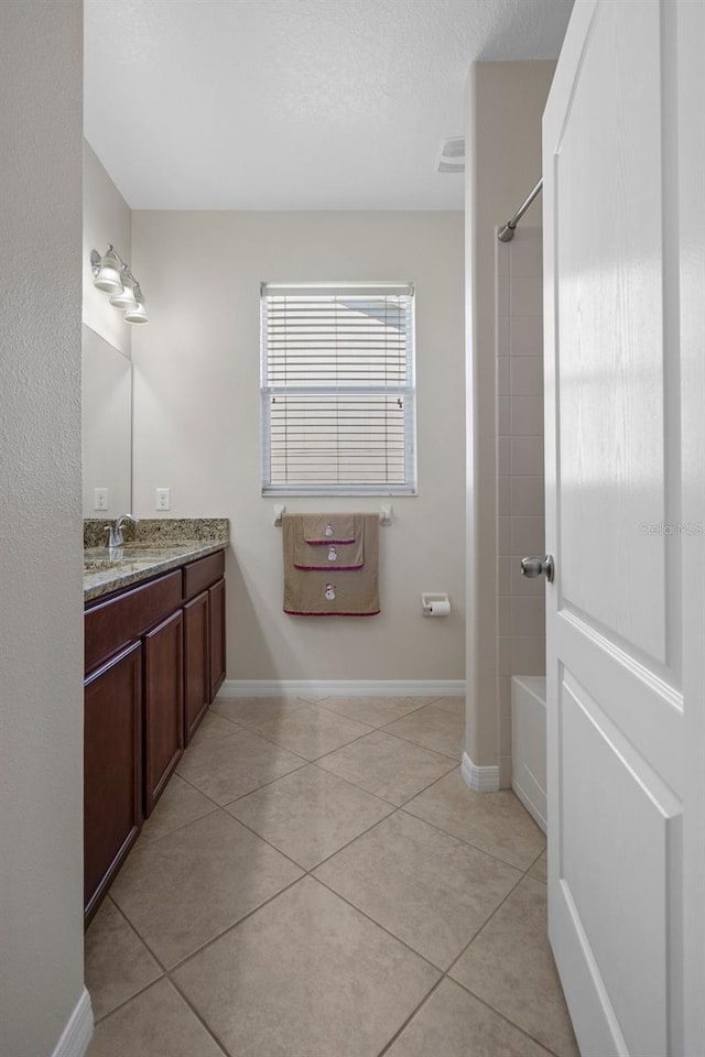 bathroom featuring vanity, baseboards, visible vents, tub / shower combination, and tile patterned floors